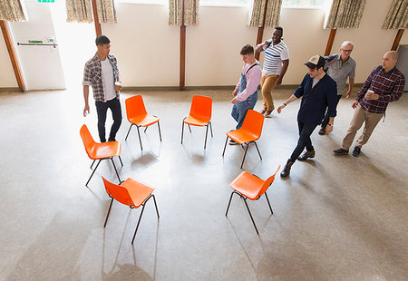 simsearch:6113-09220733,k - Men arriving at group therapy, sitting in circle in community center Stock Photo - Premium Royalty-Free, Code: 6113-09220735