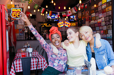 simsearch:6113-09239675,k - Portrait exuberant young women friends at bar Photographie de stock - Premium Libres de Droits, Code: 6113-09239652