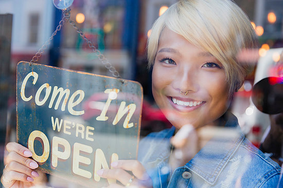 Portrait confident young female shop owner holding Open sign at window Stock Photo - Premium Royalty-Free, Image code: 6113-09239681