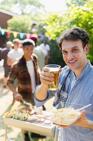 salada de repolho cru cortado fino - Portrait happy man drinking beer and barbecuing in backyard Foto de stock - Royalty Free Premium, Número: 6113-09239742
