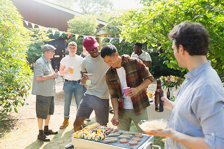 simsearch:614-06335965,k - Male friends drinking beer and barbecuing in sunny summer backyard Foto de stock - Royalty Free Premium, Número: 6113-09239758