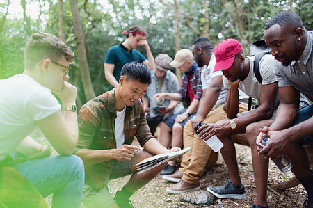 Mens group with map preparing for hike in woods Stock Photo - Premium Royalty-Free, Code: 6113-09239774