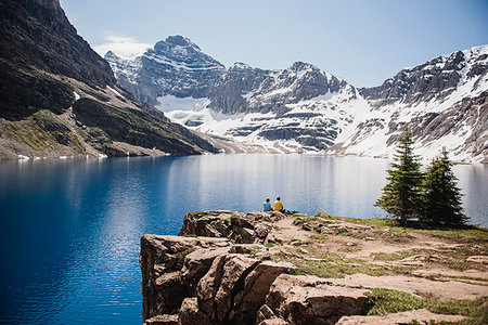 simsearch:6119-08267932,k - Couple sitting on cliff overlooking tranquil, sunny mountains and lake, Yoho Park, British Columbia, Canada Stock Photo - Premium Royalty-Free, Code: 6113-09239847