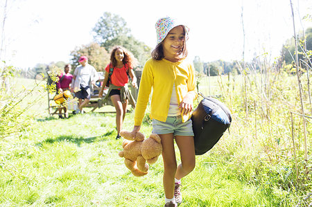 sleeping bag woman - Girl camping with family, carrying sleeping bag and teddy bear Stock Photo - Premium Royalty-Free, Code: 6113-09239861