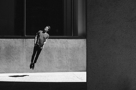 simsearch:6113-06626093,k - Young man jumping on urban sidewalk Fotografie stock - Premium Royalty-Free, Codice: 6113-09239816