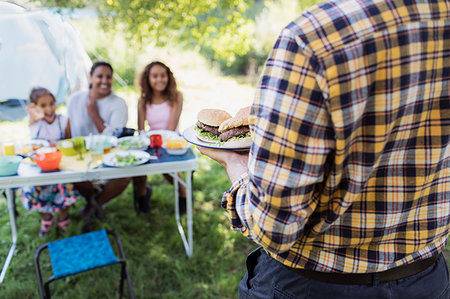 people carrying lunch - Father serving barbecue hamburgers to family at campsite table Stock Photo - Premium Royalty-Free, Code: 6113-09239957