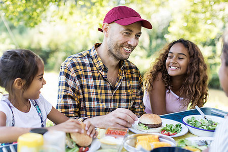 family eating burgers - Happy father and daughters enjoying barbecue lunch Stock Photo - Premium Royalty-Free, Code: 6113-09239964