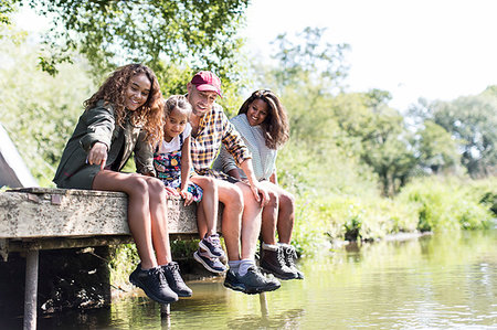 simsearch:6108-06167384,k - Family sitting on sunny riverside dock Stock Photo - Premium Royalty-Free, Code: 6113-09239993