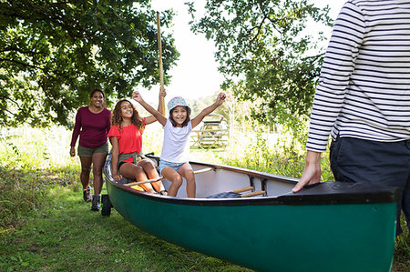 Excited family carrying canoe in woods Stock Photo - Premium Royalty-Free, Code: 6113-09239904