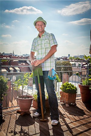 rooftop - Young Man On Balcony Holding Shovel, Munich, Bavaria, Germany, Europe Photographie de stock - Premium Libres de Droits, Code: 6115-06778650