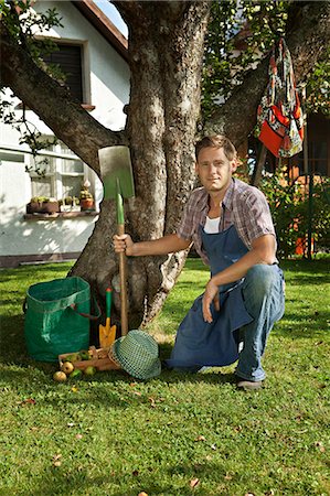 simsearch:6115-06778642,k - Mid adult man poses next to apple tree in garden, Munich, Bavaria, Germany Stock Photo - Premium Royalty-Free, Code: 6115-06778621