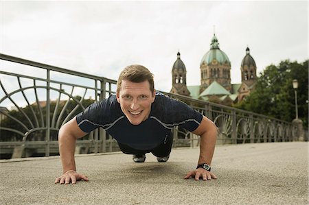 simsearch:841-07083768,k - Young man doing push-ups on bridge, Munich, Bavaria, Germany Photographie de stock - Premium Libres de Droits, Code: 6115-06778922