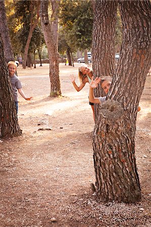 Croatia, Dalmatia, Children Behind Trees Waving Stock Photo - Premium Royalty-Free, Code: 6115-06732843