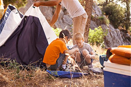 father son camping woods - Croatia, Dalmatia, Family pitching the tent on camp site Stock Photo - Premium Royalty-Free, Code: 6115-06732814