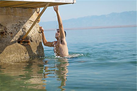 Croatia, Young man climbing a jetty by the sea Foto de stock - Sin royalties Premium, Código: 6115-06732977