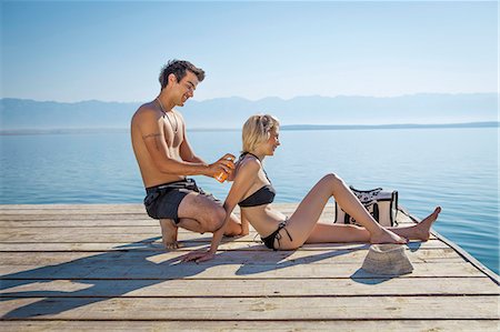 simsearch:6115-06732976,k - Croatia, Young man applying sunscreen to woman Fotografie stock - Premium Royalty-Free, Codice: 6115-06732974