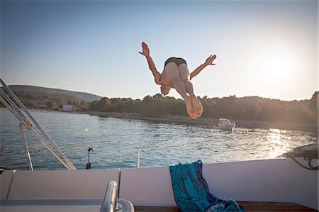 simsearch:6115-06733152,k - Croatia, Adriatic Sea, Young man diving into water, rear view Stockbilder - Premium RF Lizenzfrei, Bildnummer: 6115-06733144