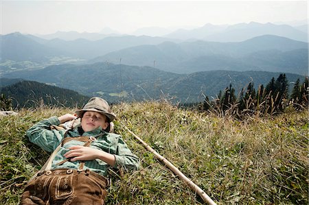 people scenic view sky hiking summer - Germany, Bavaria, Boy in traditional clothing sleeps in the mountains Stock Photo - Premium Royalty-Free, Code: 6115-06733165
