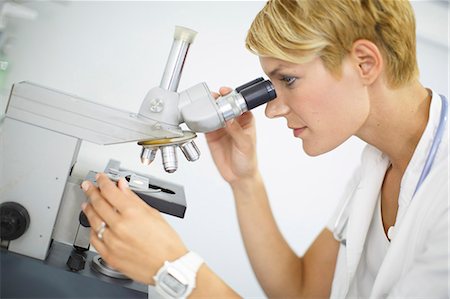 Female Scientist looks through a microscope Photographie de stock - Premium Libres de Droits, Code: 6115-06733179
