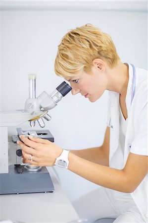 Female Scientist looks through a microscope Photographie de stock - Premium Libres de Droits, Code: 6115-06733182