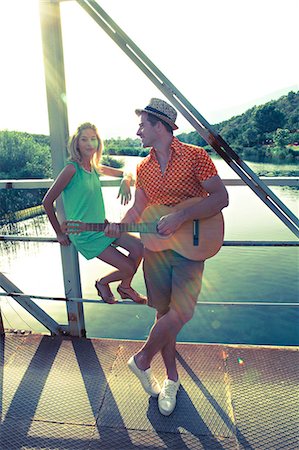 Croatia, Dalmatia, Young couple on a footbridge, man playing guitar Foto de stock - Sin royalties Premium, Código: 6115-06733113