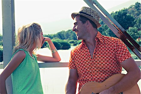 friends by river - Croatia, Dalmatia, Young couple on a footbridge, man playing guitar Stock Photo - Premium Royalty-Free, Code: 6115-06733115