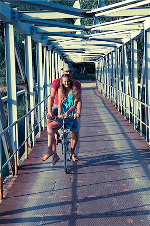 even - Croatia, Dalmatia, Young couple on footbridge, riding a bike Stock Photo - Premium Royalty-Free, Code: 6115-06733116