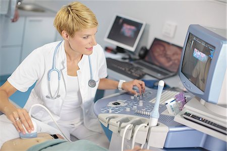 diagnostic - Pregnant woman having an ultrasound Stock Photo - Premium Royalty-Free, Code: 6115-06733286