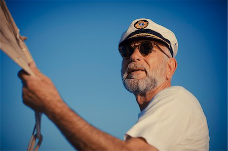 simsearch:6115-06733079,k - Croatia, Senior man with captain's hat steering sailboat Stock Photo - Premium Royalty-Free, Code: 6115-06733322