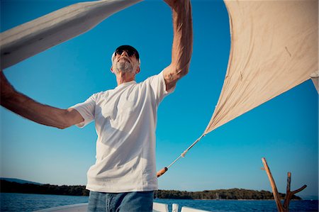 simsearch:6115-07539676,k - Croatia, Senior man with captain's hat steering sailboat Photographie de stock - Premium Libres de Droits, Code: 6115-06733324