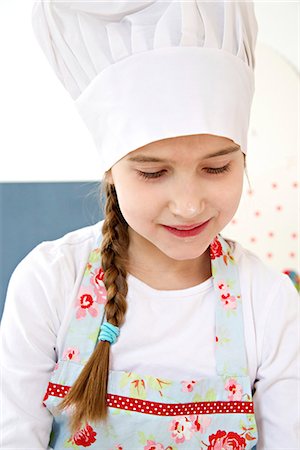 Little girl with chef's hat, Munich, Bavaria, Germany Stock Photo - Premium Royalty-Free, Code: 6115-06966919