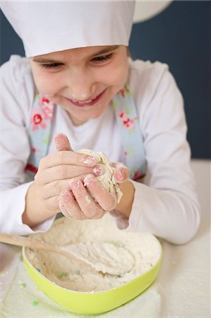 Little girl with chef's hat kneading dough, Munich, Bavaria, Germany Stock Photo - Premium Royalty-Free, Code: 6115-06966928