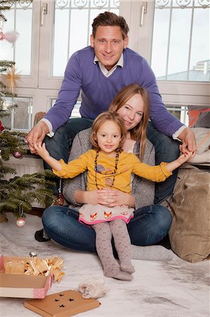 family relaxing at christmas - Parents with daughter alongside Christmas tree, Munich, Bavaria, Germany Stock Photo - Premium Royalty-Free, Code: 6115-06967055