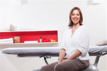 simsearch:6115-08066527,k - Female osteopath sitting in Physiotherapy Practice, Munich, Bavaria, Germany Stock Photo - Premium Royalty-Free, Code: 6115-06967017