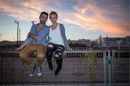 simsearch:6115-06778646,k - Young couple sitting on a fence, Munich, Bavaria, Germany Foto de stock - Sin royalties Premium, Código: 6115-06967028