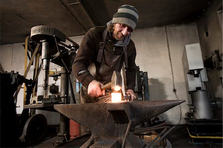 Blacksmith hammering metal on an anvil, Landshut, Bavaria, Germany Photographie de stock - Premium Libres de Droits, Code: 6115-06967107