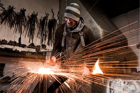 Blacksmith hammering metal on an anvil, Landshut, Bavaria, Germany Stock Photo - Premium Royalty-Free, Code: 6115-06967109