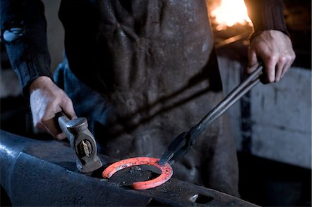 ferradura - Blacksmith hammering a horseshoe, Landshut, Bavaria, Germany Foto de stock - Royalty Free Premium, Número: 6115-06967122