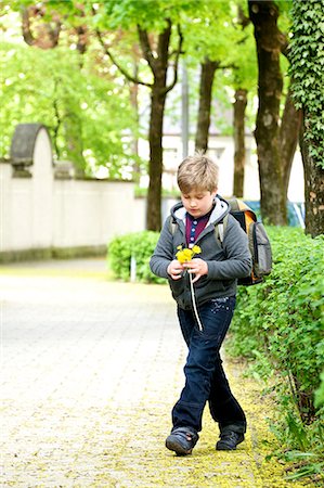 simsearch:6115-07109598,k - Little schoolboy walks to school, holding flowers, Munich, Bavaria, Germany Foto de stock - Royalty Free Premium, Número: 6115-07109653
