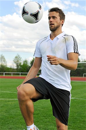 simsearch:6115-07109919,k - Soccer player bouncing ball on knee, Munich, Bavaria, Germany Photographie de stock - Premium Libres de Droits, Code: 6115-07109912