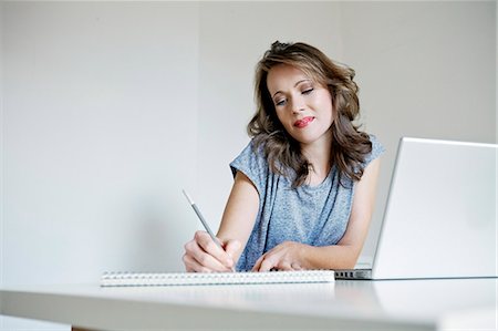 simsearch:6115-08066527,k - Young woman taking notes at home, Munich, Bavaria, Germany Stock Photo - Premium Royalty-Free, Code: 6115-07282732