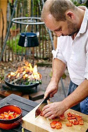 simsearch:6115-06732939,k - Man Cutting Fresh Bell Pepper Stock Photo - Premium Royalty-Free, Code: 6115-07282734