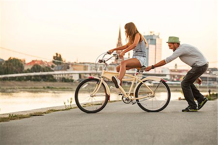 Young couple with bicycle, having fun, Osijek, Croatia Stock Photo - Premium Royalty-Free, Code: 6115-07282907