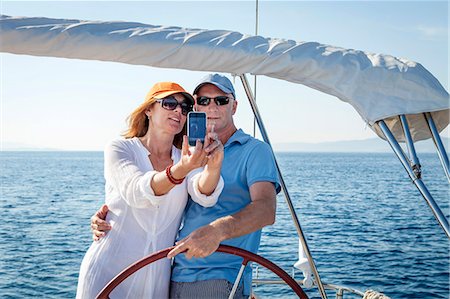 Mature couple sailing together, taking pictures, Adriatic Sea, Croatia Stock Photo - Premium Royalty-Free, Code: 6115-07539695