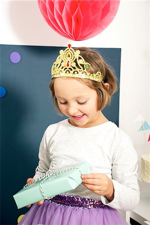 face of carnival - Birthday party, girl in costume holding present, Munich, Bavaria, Germany Stock Photo - Premium Royalty-Free, Code: 6115-08066228