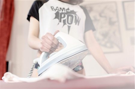 Young woman ironing clothes Fotografie stock - Premium Royalty-Free, Codice: 6115-08066476