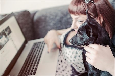 simsearch:6115-08066516,k - Young woman using laptop alongside her pet dog Fotografie stock - Premium Royalty-Free, Codice: 6115-08066496