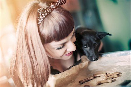 Young woman baking biscuits for her pet dog Foto de stock - Sin royalties Premium, Código: 6115-08066506