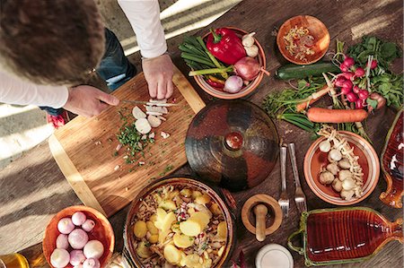 simsearch:6115-06732939,k - Man cutting onions alongside variety of vegetables Stock Photo - Premium Royalty-Free, Code: 6115-08066631