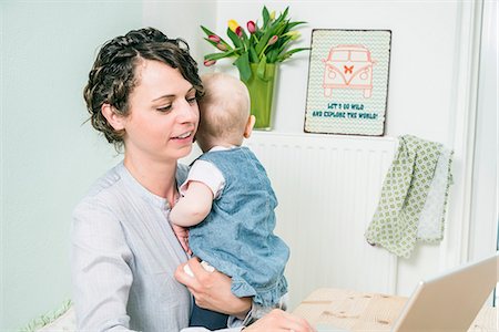 Mother working at home baby in her arms Stock Photo - Premium Royalty-Free, Code: 6115-08149197